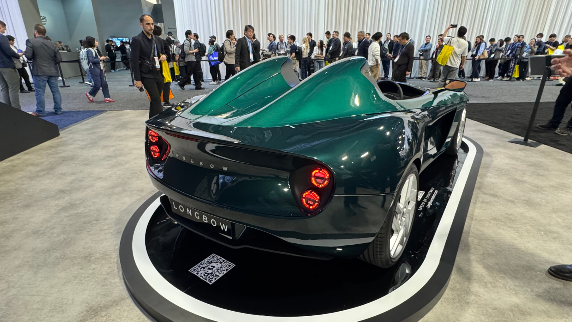 A green Longbow electric roadster on a turntable at CES 2026